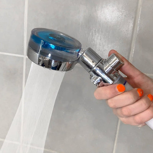 Mano usando la ducha turbo con chorro de agua de alta presión